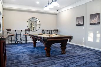 A game room with a pool table and chairs